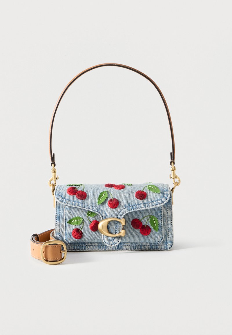 Sac à main en denim avec cerises brodées rouges, feuilles vertes, fermoir en or et bandoulière amovible en cuir marron.