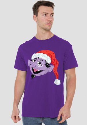 Lila T-Shirt mit einem Cartoon-Charakter in einem roten Weihnachtsmannhut mit weißer Borte, kurzen Ärmeln und rundem Ausschnitt. Weiche Stofftextur.