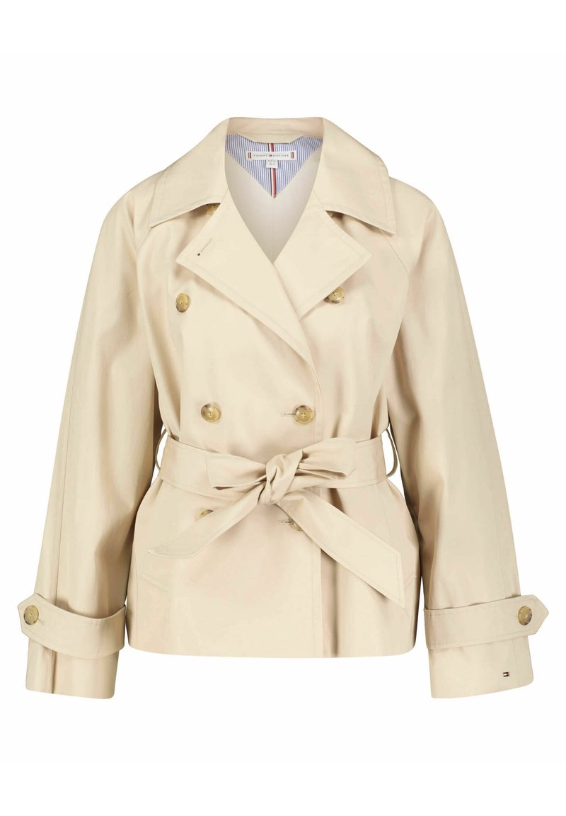 Beżowy trencz z dwurzędowym zapięciem, dużymi klapami, wiązanym paskiem w talii i mankietami na guziki; wykonany z gładkiego, lekkiego materiału.