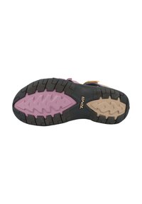Black rubber shoe sole with a textured pattern, featuring a pink middle section and beige accents. Logo "Teva" is visible on the side.