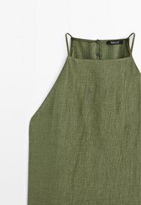 Olivengrøn linnedkjole med en løs pasform, justerbare spaghetti-stropper og knaplukning på ryggen. Glat tekstur og minimalistisk design.