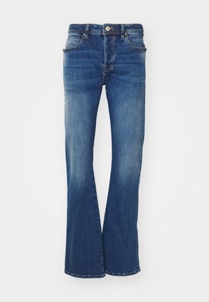 Blå utsvängda denimjeans med midja i mellanläge, fem fickor och subtila blekningar. Tyget har en klassisk textur och en ren finish.