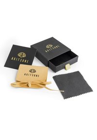 Black gift box with logo, yellow suede pouch with tie, cleaning cloth, and a black card featuring a gold lotus design.