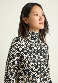 Black high-neck top with an abstract beige pattern; made of smooth fabric, featuring a fitted silhouette and long sleeves.