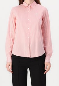 Rood en wit gestreepte overhemd met knopen, met een kraag, lange mouwen en een licht gebogen zoom, gemaakt van een lichte stof.