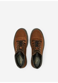 Braune Wildlederstiefel mit schwarzer Gummisohle, runder Zehenpartie, ausgeprägtem Schnürsystem und gepolsterter Knöchelpartie. Goldenes Logo auf der Innensohle.