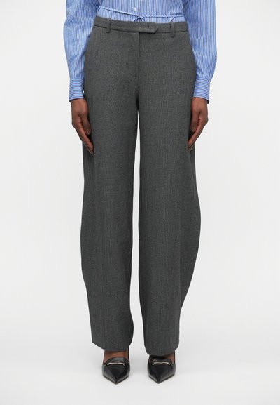 Pantalons larges gris avec un motif pied-de-poule, dotés d'une taille ajustée et de plis. Associés à des chaussures noires sleek à bout pointu.