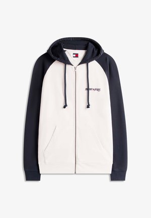 Kapuzensweatshirt mit durchgehendem Reißverschluss, cremefarbenem Vorderteil und marineblauen Ärmeln, navy Kordeln an der Kapuze, Fronttaschen und „Tommy Jeans“-Logo auf der Brust.