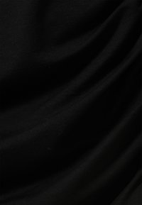 Musta kangas, jossa sileä pinta ja hienovaraiset laskokset ja ryppyjä. Materiaali vaikuttaa kevyeltä ja joustavalta, eikä siinä ole näkyviä kuvioita.