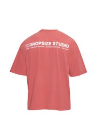 Dos d'un t-shirt rouge délavé à manches courtes avec texte blanc « ©DROPSIZE STUDIO » et texte plus petit en dessous en haut du dos.