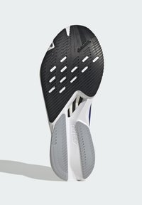 Sort gummiydersål med tekstureret greb, hvid mellemsål og grå accenter. Har ventilationshuller og "ADIZERO" logo.