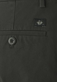 Pantaloni verde scuro in tessuto resistente, dotati di una tasca frontale, chiusura con bottone con marchio "Dockers" e una toppa del logo cucita.
