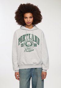 Felpa grigia con cappuccio e tasca frontale, caratterizzata da una stampa grafica verde che include "Portland", un orso e "Oregon".