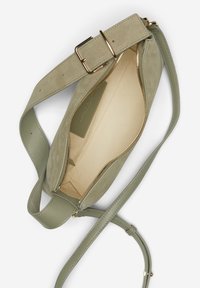 Grüne Wildleder-Crossbody-Tasche mit Reißverschluss, verstellbarem Riemen und beigem Innenfutter. Hardware in goldfarbener Ausführung betont das Design.