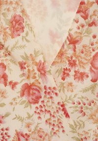 Tissu floral présentant des fleurs roses, rouges et oranges sur un fond crème pâle, avec une texture douce et délicate et des accents subtils de verdure.