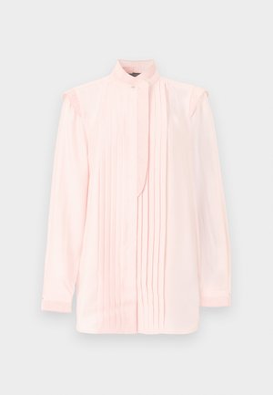 Jasnoróżowa bluzka z długim rękawem, z pionowymi plisami na przodzie, wysokim kołnierzem zapinanym na guziki oraz delikatnie marszczonymi detalami na ramionach.