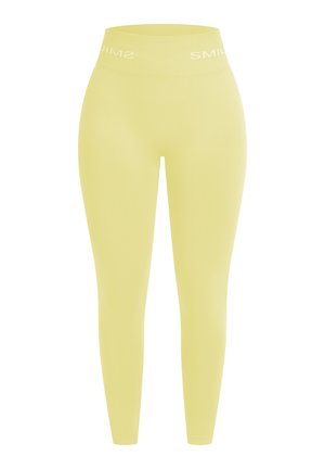 Leggings amarillos fabricados con un tejido elástico, que presentan una cintura alta con la marca "SMIL". Textura suave y diseño ajustado.