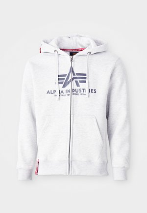Grå zip-up hoodie i mjukt tyg, med ett fram-tryckt logo, justerbara dragsnören och sidofickor. Röd accent vid fållen.