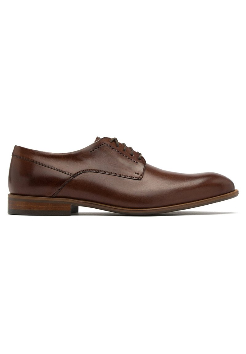Brązowe skórzane buty eleganckie z gładką powierzchnią, okrągłym czubkiem i subtelnymi detalami haftu. Posiadają niski, wystający obcas oraz sznurowane zapięcie.