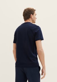 Navy blue cotton t-shirt with short sleeves, classic crew neck, and a relaxed fit. Smooth texture with no visible patterns or accents.