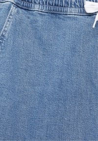 Lichtblauwe denimstof met zichtbare stiksels, tailleband met riemlussen en gedeeltelijk zichtbare witte koord.