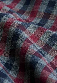 Katoenen stof met een ruitpatroon in marineblauw, bordeauxrood en grijs, met verschillende tinten en een gestructureerde weving.