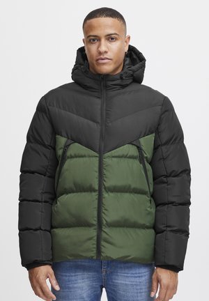 Sort og grøn pufjakke med lynlås foran, hætte og chevrondesign. Har lynlåslommer og en puffy tekstur. Justerbar hætte.