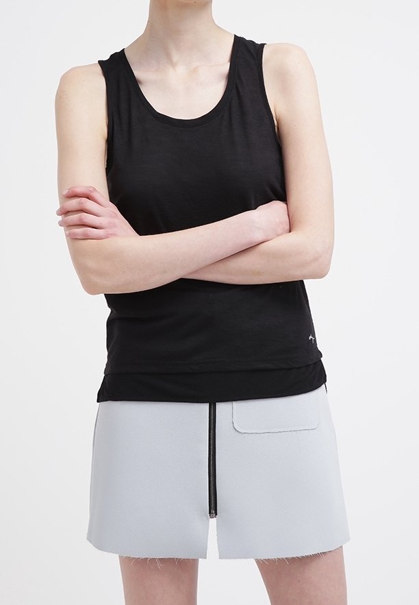 Svart linne i mjukt tyg med rundad halsringning, kombinerat med en ljusgrå kjol med framdraget blixtlås och laga ficka.