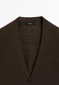 Tmavě hnědý kardigan s výstřihem do V a jedním knoflíkem, označený "Massimo Dutti", vystavený na bílém pozadí.