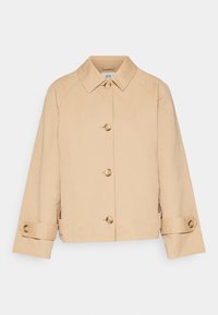 Beige zkrácená bunda s límečkem, která má šest kulatých knoflíků a manžety s knoflíky. Hladká tkanina s uvolněným střihem.