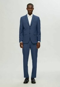 Ανδρικό μπλε κοστούμι που περιλαμβάνει σακάκι με ένα κούμπωμα και πέτο κατηγορίας, παντελόνι στενής εφαρμογής και λευκό πουκάμισο. Λείος ύφασμα και ραμμένη σχεδίαση.