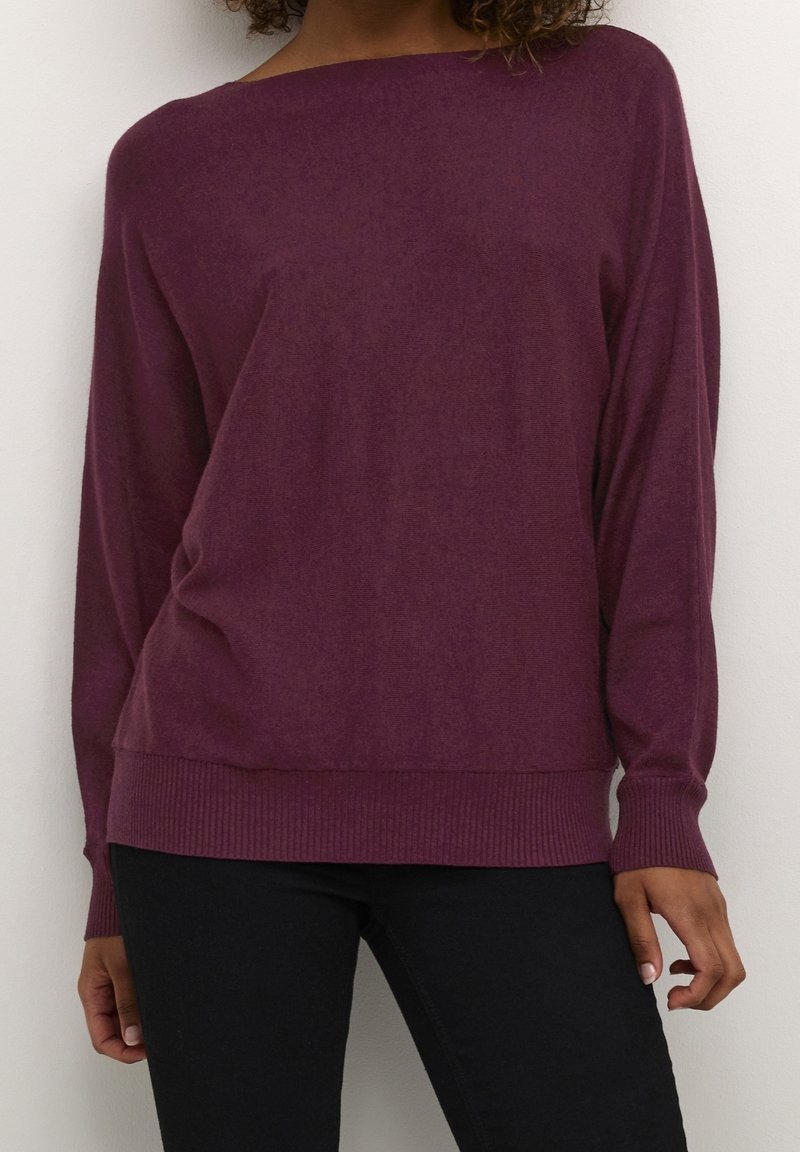 Lila, löst sittande tröja med breda axlar och ribbade ärmmuddar. Tillverkad av mjukt tyg, har en slät textur och en minimalistisk design.