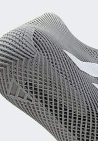 Pilnas artimas planas pilko sportinio batelio padažo su detaliu tinklelio raštu ir baltomis logotipo detalėmis.