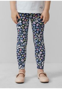 Blumige Leggings mit navyblauem Hintergrund und bunten Blumen sowie Erdbeeren, aus einem dehnbaren Material; kombiniert mit rosa Schuhen.