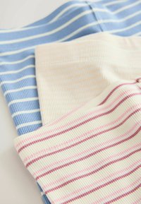 Trzy pary legginsów z prążkowanej tkaniny: jasnoniebieskie w białe paski, kremowe w różowe paski i pastelowe beżowe w burgundowe paski.