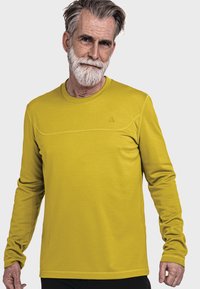 Langarm-Sportshirt in leuchtendem Gelb, aus strukturiertem Stoff mit nahtlosem Design und einem dezenten Logo auf der Brust.