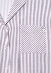 Purple and white striped pajama top with a notched collar, three pearly buttons, and a square pocket featuring a small logo.