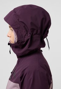 Giacca impermeabile viola con cappuccio regolabile, dotata di chiusura con zip e un'area più chiara in contrasto nella parte anteriore bassa.