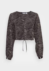 Top cropped preto com um padrão branco salpicado, mangas longas, decote redondo e bainha com cordão. Feito de tecido leve.