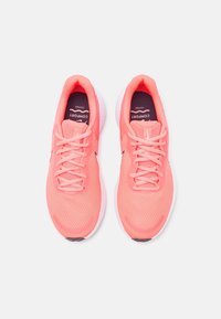 Chaussures de course légères roses avec tige en mesh, lacets plats, semelle coussinée et semelle intermédiaire blanche contrastée, avec le logo "COMFORT" à l'intérieur.