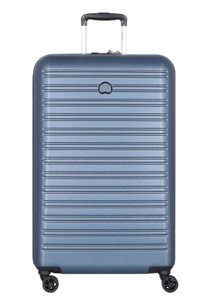 Hard-shell suitcase in navy blue, featuring a textured ribbed design, retractable handle, and four black spinner wheels for mobility.