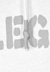 Vit hoodie med grå text. Har en flätad dragsko med en plastspets formad som en hand som greppar änden. Texten är fet och har struktur.