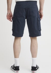 Tengerészkék munkaruházati rövidnadrág oldalzsebekkel, övbújtatókkal és varrott részletekkel; pamut anyagból készült, laza, hétköznapi dizájnnal.