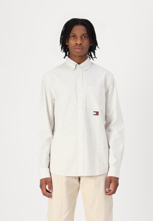Lett stripete skjorte med knapper i beige og hvitt, med brystlomme og logo-patch, laget av et mykt stoff med en jevn tekstur.