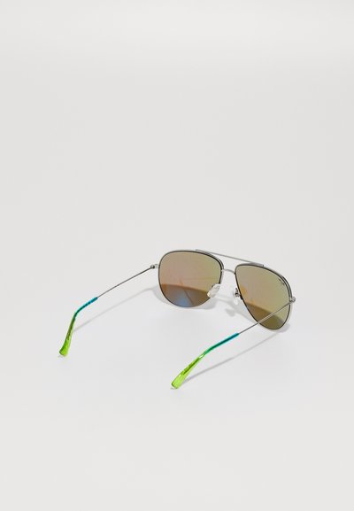 Occhiali da sole aviatori in metallo con lenti gradiente marroni, montatura argento e punte delle asticelle testurizzate verde e blu. Cuscinetti nasali trasparenti attaccati.