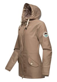 Beige waterproof jacket with a hood, front zipper, two side pockets, and adjustable drawstrings. Features a logo patch on the sleeve.