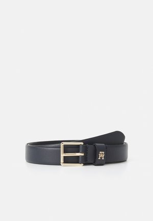 Cintura in pelle blu navy con fibbia in metallo dorato. Presenta una texture liscia, un accento con logo e una forma rettangolare classica.