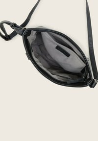 Schwarze Leder-Crossbody-Tasche mit verstellbarem Schultergurt, Reißverschluss oben, grauer Stoffauskleidung und einer kleinen Innentasche.