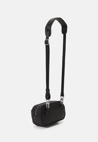 Borsa rettangolare nera realizzata in materiale testurizzato, con chiusura a zip, tracolla regolabile e dettagli in metallo argentato.