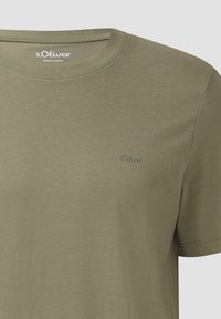Olivenfarbene Baumwoll-T-Shirt mit Rundhalsausschnitt und kurzen Ärmeln. Verfügt über ein dezentes, geprägtes Logo in passendem Faden auf der Brust.
